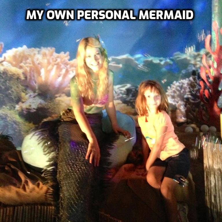 A young girl dressed as a mermaid, and a younger girl next to her